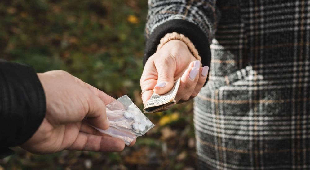 a person handing another person something out of a bag