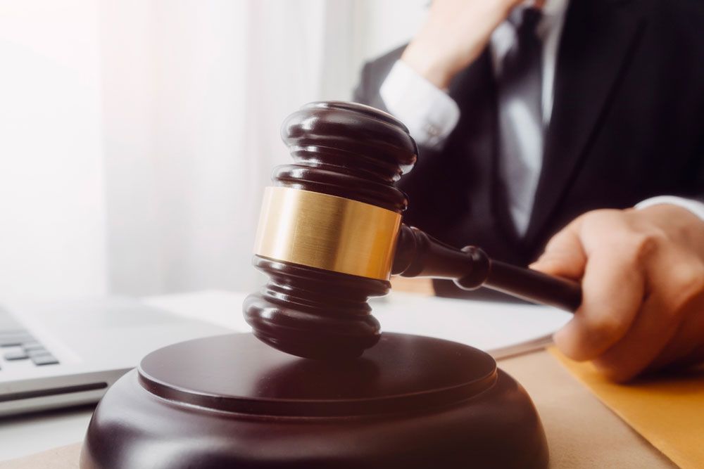 Judge striking gavel, symbolizing legal decisions in a courtroom setting.