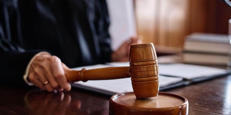 a judge holding a wooden gaven on top of a wooden table