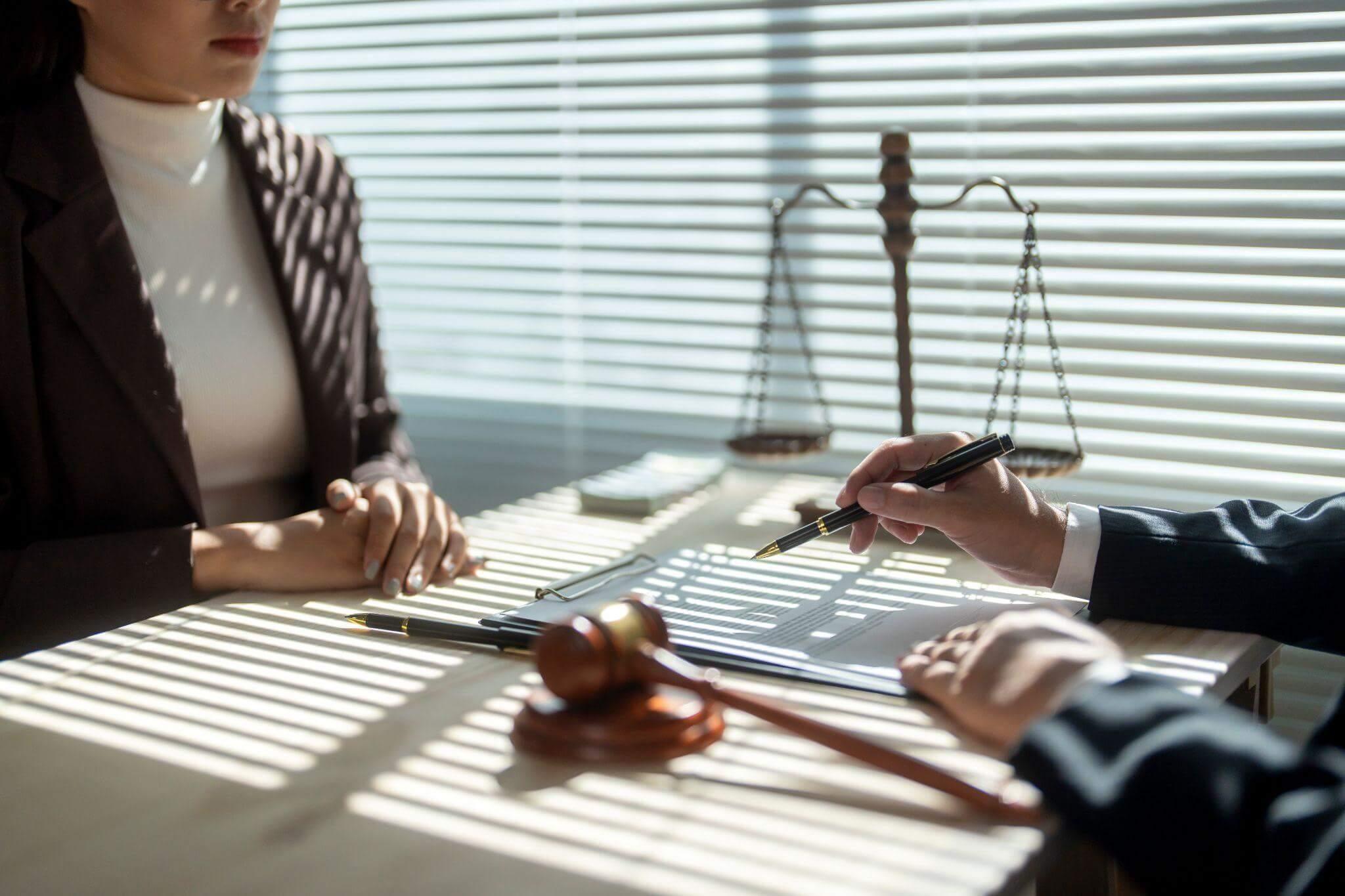a woman sitting at a table in front of a judge
